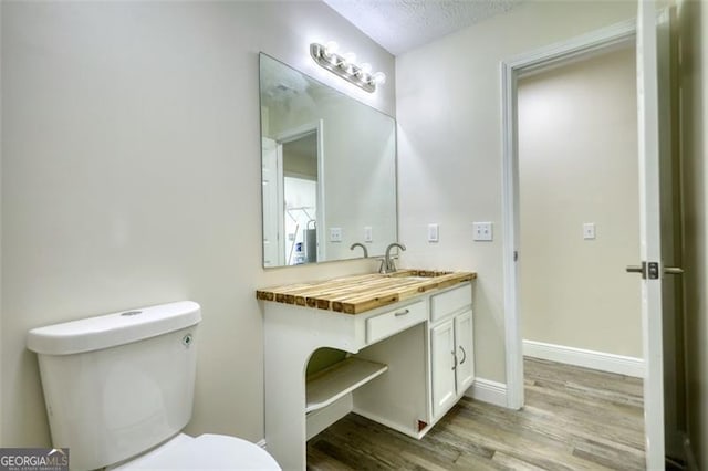 479 Lakeview Dr, Dahlonega, GA 30533 - bathroom with a textured ceiling, toilet, baseboards, wood finished floors, and vanity