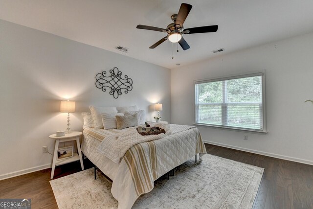 bedroom with baseboards, wood finished floors, and a ceiling fan