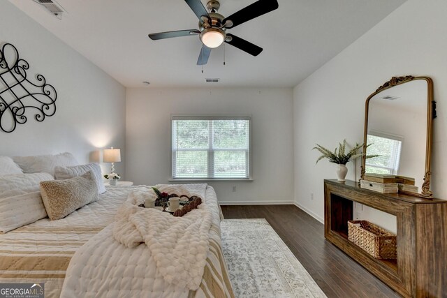 bedroom with dark wood-style floors, baseboards, and ceiling fan