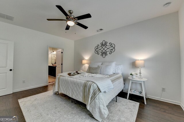 bedroom featuring baseboards, dark wood-type flooring, ceiling fan, and ensuite bath