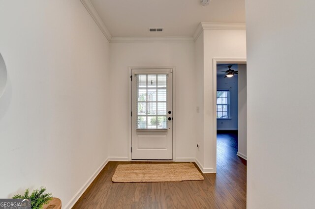 doorway with dark wood finished floors, crown molding, and baseboards