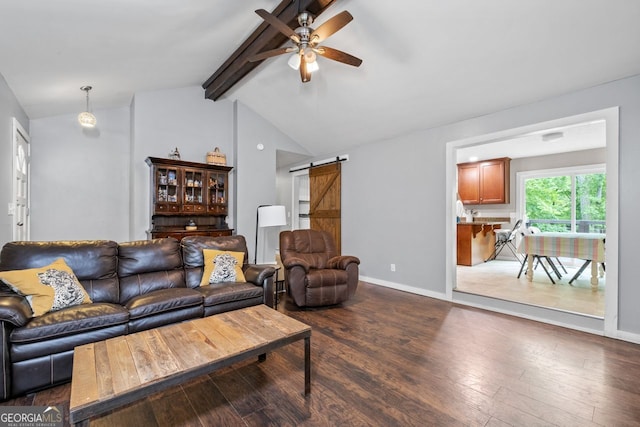 living room with dark wood-style floors, a barn door, lofted ceiling with beams, a ceiling fan, and baseboards