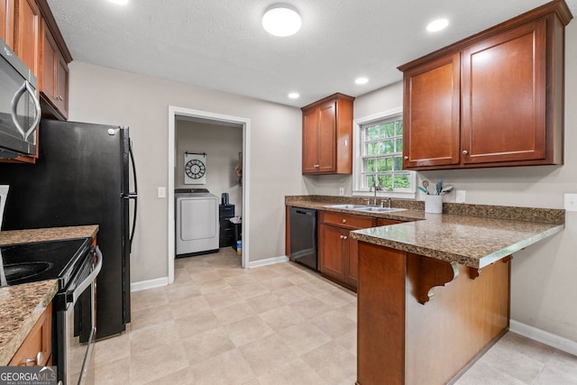kitchen featuring baseboards, a peninsula, appliances with stainless steel finishes, and a sink