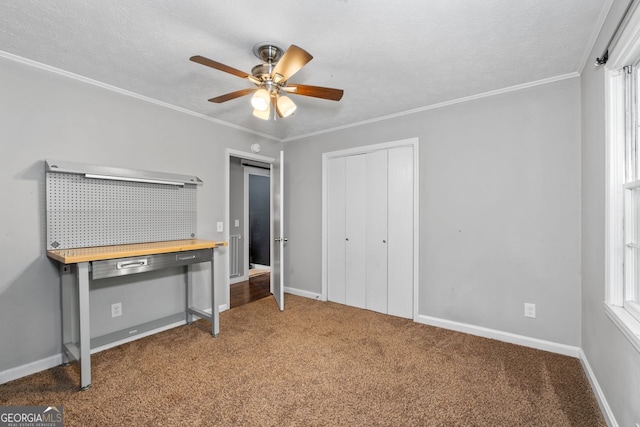 unfurnished bedroom with crown molding, a closet, carpet, and baseboards