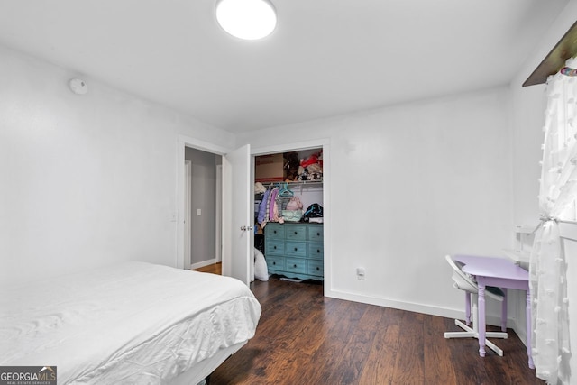bedroom with a closet, wood finished floors, and baseboards