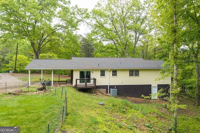 back of property with a carport, central AC unit, a yard, and a deck