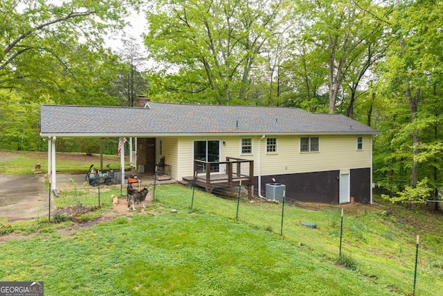 view of front of home featuring a chimney, cooling unit, a front yard, and a wooden deck