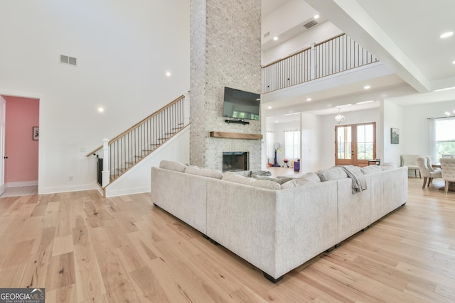 5315 Hendrix Rd, Cumming, GA 30040 - living area with stairway, a high ceiling, light wood finished floors, and visible vents