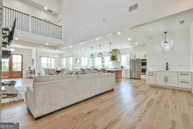 5315 Hendrix Rd, Cumming, GA 30040 - living area featuring light wood-style floors, a high ceiling, recessed lighting, and visible vents