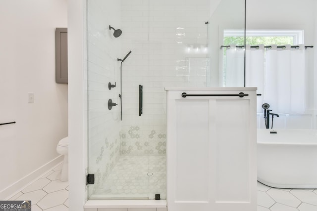 5315 Hendrix Rd, Cumming, GA 30040 - bathroom featuring a freestanding tub, a shower stall, tile patterned floors, baseboards, and toilet