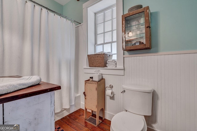 590 Dogwood Way, Richmond Hill, GA 31324 - full bath featuring shower / bathtub combination with curtain, wood finished floors, toilet, and a wainscoted wall