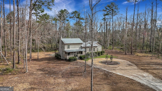 590 Dogwood Way, Richmond Hill, GA 31324 - view of front of home with a porch, dirt driveway, a forest view, and metal roof