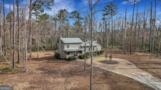 590 Dogwood Way, Richmond Hill, GA 31324 - view of front facade featuring metal roof, dirt driveway, and a forest view