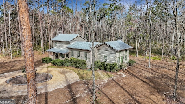 590 Dogwood Way, Richmond Hill, GA 31324 - view of front of home with a chimney, driveway, and metal roof