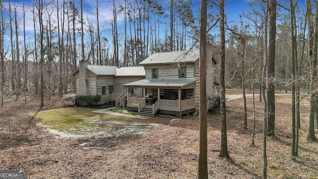 590 Dogwood Way, Richmond Hill, GA 31324 - exterior space with metal roof, a porch, and a chimney