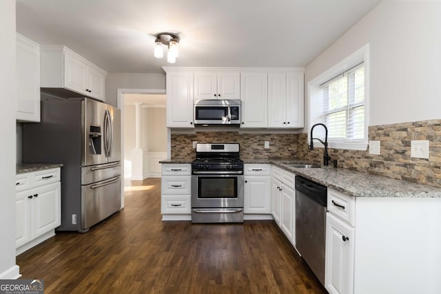 1650 Berryhill Rd, Cumming, GA 30041 - kitchen featuring a sink, white cabinetry, backsplash, appliances with stainless steel finishes, and light stone countertops