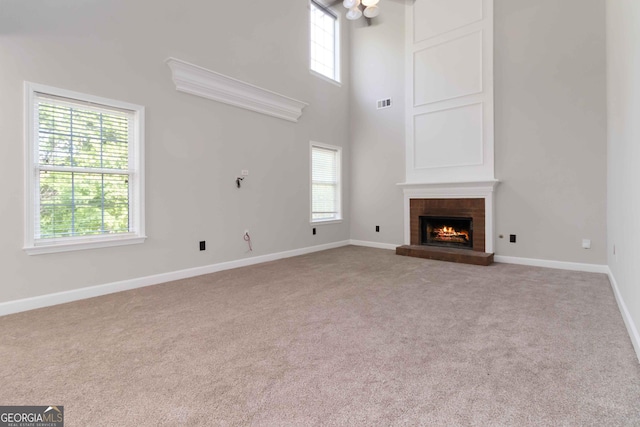 1650 Berryhill Rd, Cumming, GA 30041 - unfurnished living room with a high ceiling, visible vents, baseboards, a brick fireplace, and carpet flooring