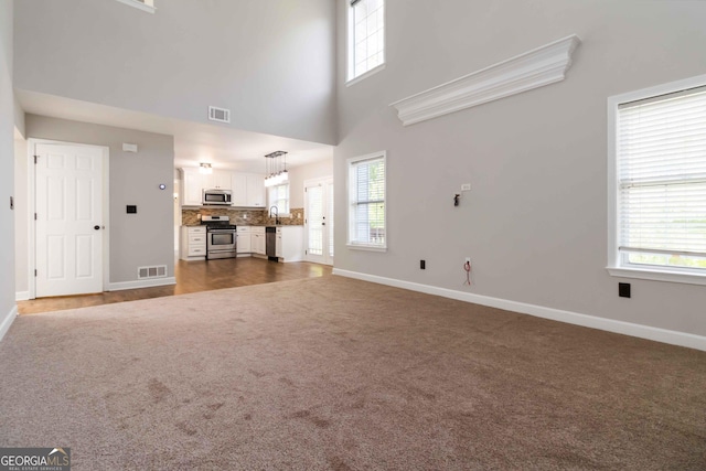 1650 Berryhill Rd, Cumming, GA 30041 - unfurnished living room featuring baseboards, dark colored carpet, and visible vents