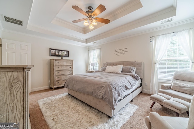 bedroom featuring crown molding, a tray ceiling, multiple windows, and visible vents