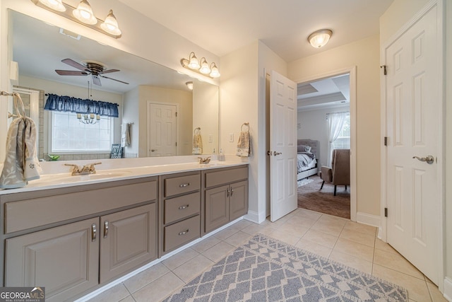 ensuite bathroom with a ceiling fan, tile patterned floors, double vanity, and a sink
