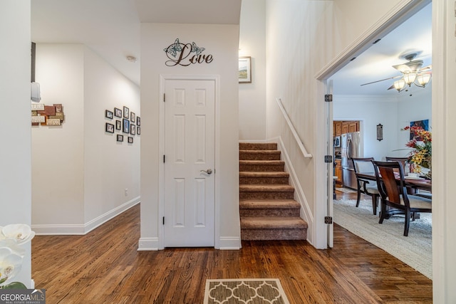 stairway featuring baseboards, a ceiling fan, and wood finished floors