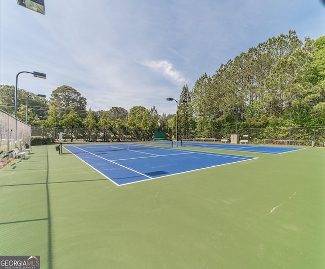 view of tennis court featuring fence