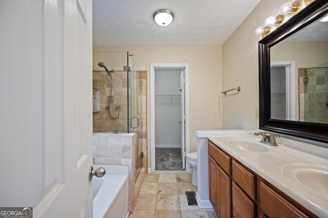 full bathroom with a stall shower, a bath, double vanity, toilet, and a textured ceiling