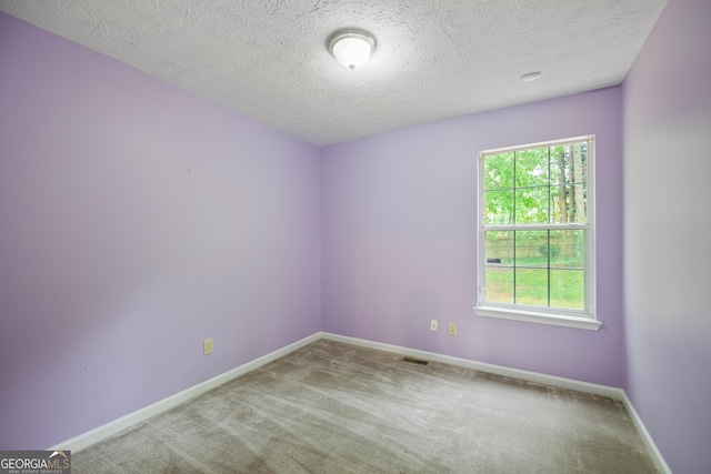 unfurnished room featuring carpet flooring, baseboards, and a textured ceiling