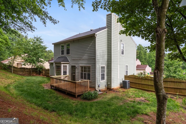 back of house featuring central air condition unit, a deck, and a chimney