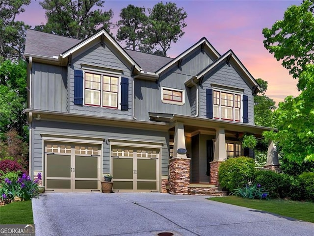 craftsman house featuring board and batten siding, a garage, covered porch, and concrete driveway