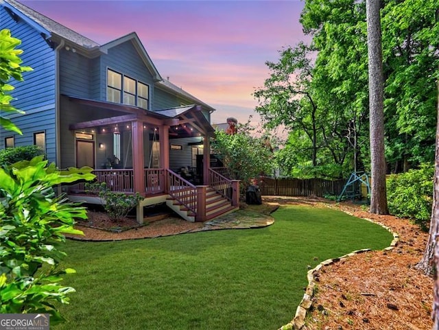 yard at dusk featuring a deck