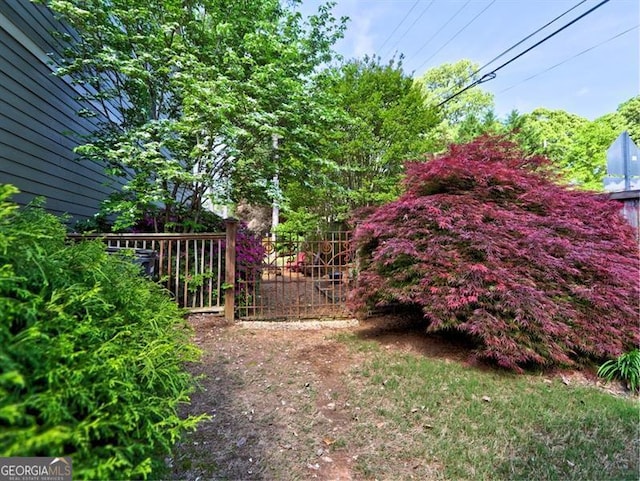yard at dusk featuring a deck, a lawn, and stairs