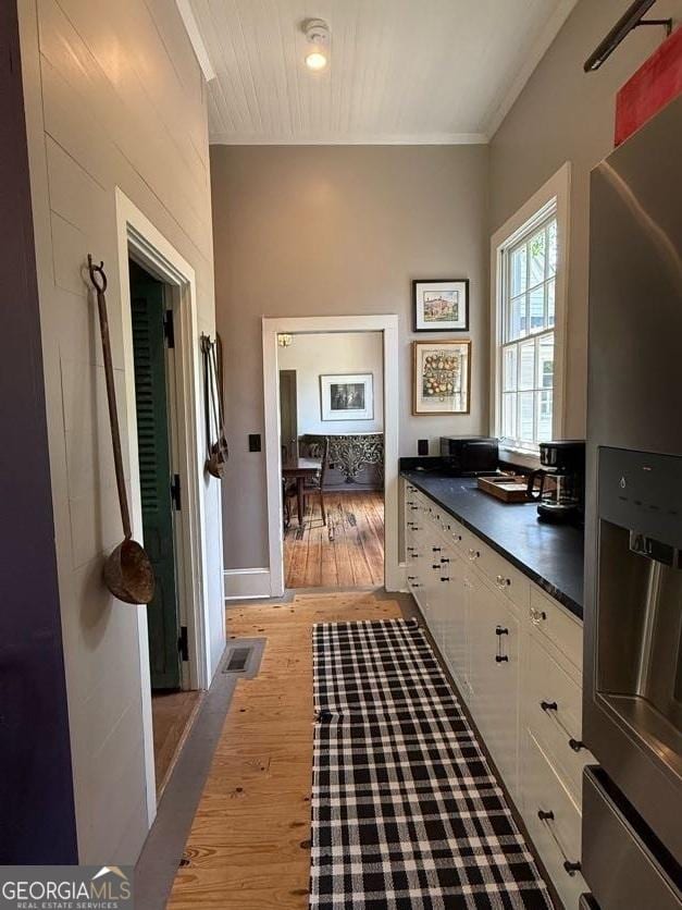 interior space with visible vents, light wood finished floors, and ornamental molding