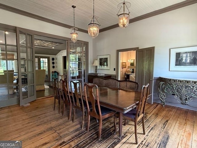 dining area with a chandelier, hardwood / wood-style floors, and ornamental molding