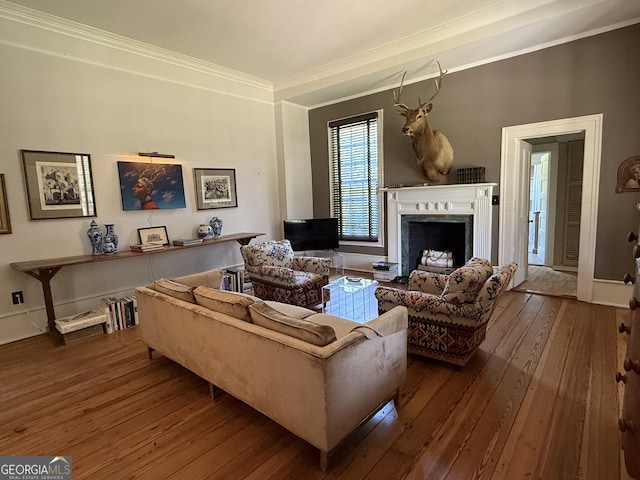 living area featuring a high end fireplace, ornamental molding, and wood-type flooring