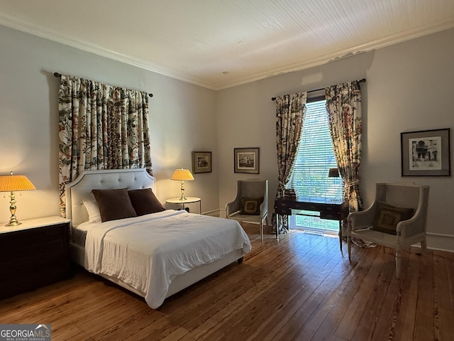 bedroom with baseboards, hardwood / wood-style flooring, and ornamental molding