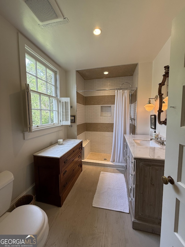 bathroom featuring recessed lighting, wood finished floors, visible vents, toilet, and a stall shower
