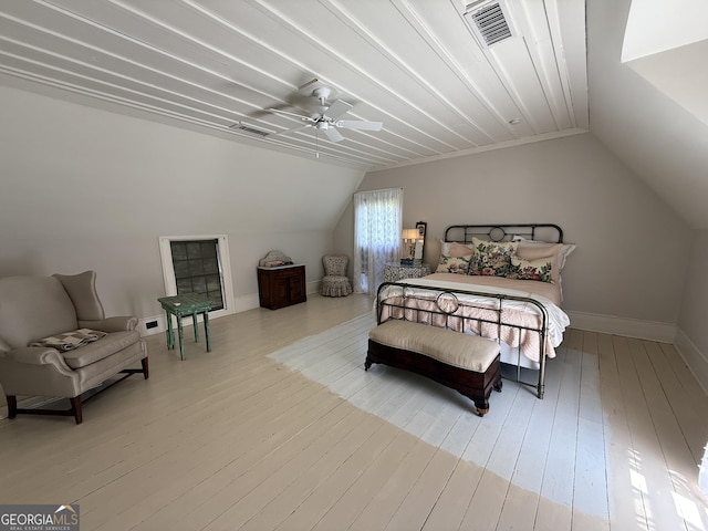 bedroom with vaulted ceiling, a ceiling fan, wood finished floors, baseboards, and visible vents
