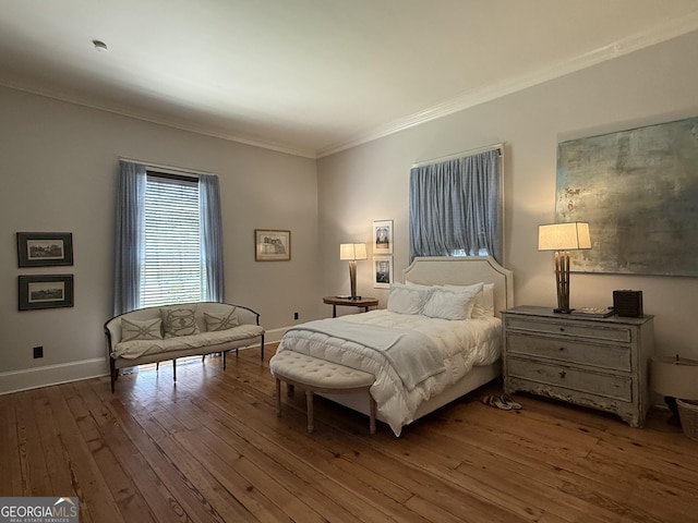 bedroom featuring hardwood / wood-style floors, baseboards, and ornamental molding