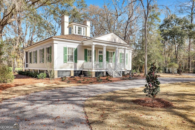 192 Myrtle Grove Ln, Richmond Hill, GA 31324 - view of front facade featuring driveway, covered porch, and a chimney