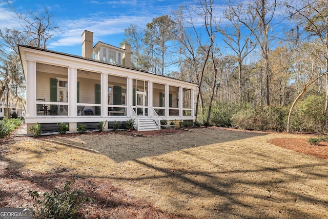 192 Myrtle Grove Ln, Richmond Hill, GA 31324 - back of house with a sunroom and a chimney