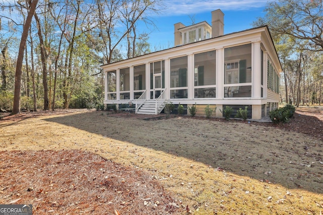 192 Myrtle Grove Ln, Richmond Hill, GA 31324 - rear view of property featuring a chimney and a sunroom