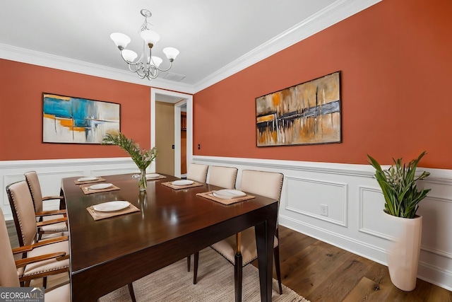 548 Myrtle Trace Ln, Suwanee, GA 30024 - dining area featuring a chandelier, crown molding, wood finished floors, and wainscoting