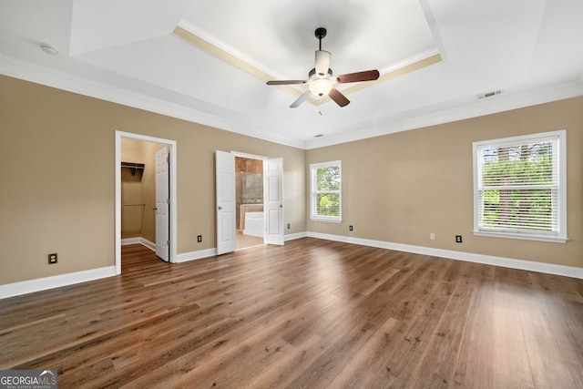 548 Myrtle Trace Ln, Suwanee, GA 30024 - unfurnished bedroom with a raised ceiling, wood finished floors, ornamental molding, a walk in closet, and ensuite bathroom