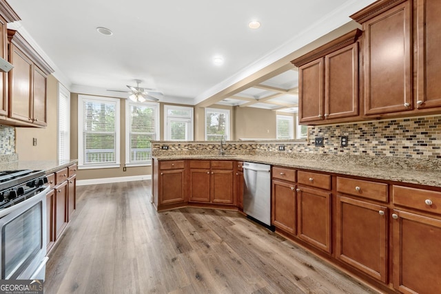 548 Myrtle Trace Ln, Suwanee, GA 30024 - kitchen featuring stainless steel appliances, light wood finished floors, brown cabinets, ceiling fan, and tasteful backsplash