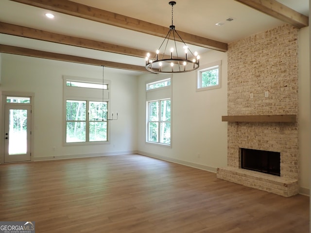 45 Hometown Ct, Jefferson, GA 30549 - unfurnished living room with beam ceiling, wood finished floors, a wealth of natural light, and a chandelier