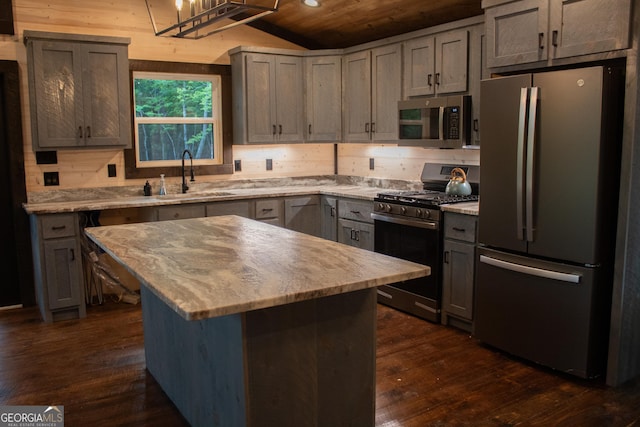 kitchen featuring wood ceiling, vaulted ceiling, dark wood finished floors, a sink, and stainless steel appliances