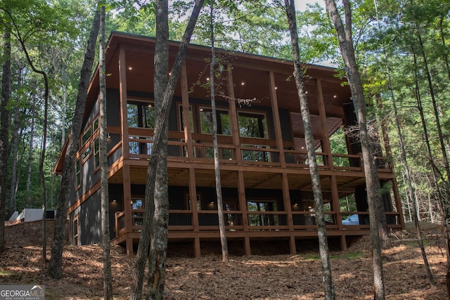 rear view of property featuring a wooden deck
