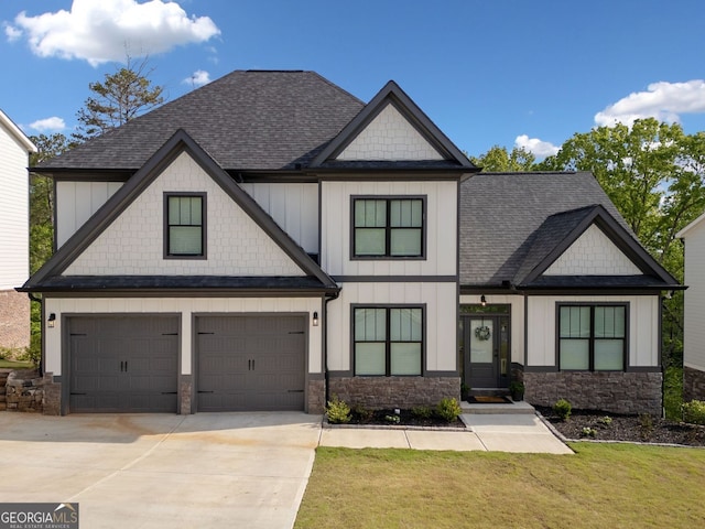 view of front of property with board and batten siding, an attached garage, a shingled roof, and concrete driveway