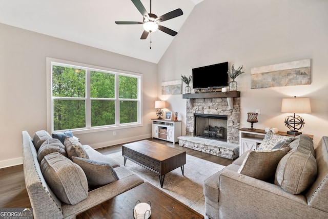 living room featuring baseboards, wood finished floors, ceiling fan, a fireplace, and high vaulted ceiling